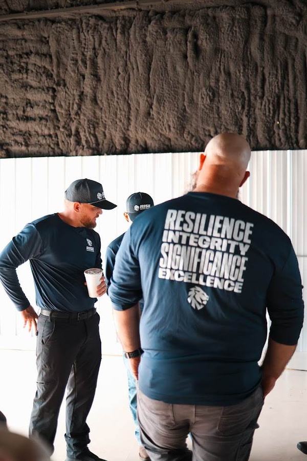 Back of a Rise shirt reading Resilience, Integrity, Significance, Excellence