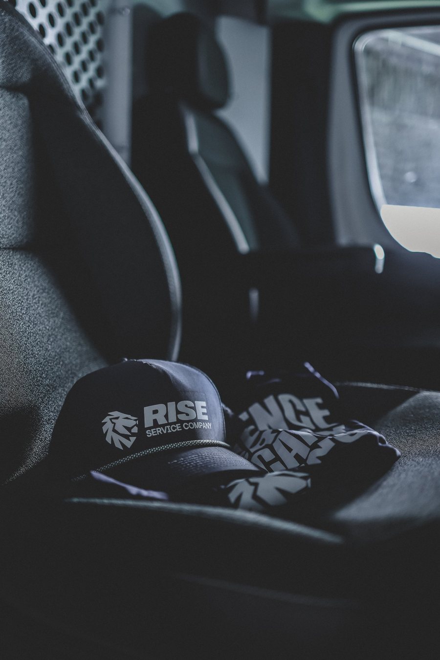 Rise Service Company hat and shirt on the seat of a Rise van