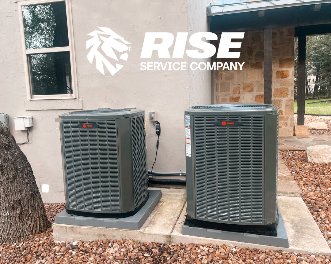 Two new Trane outdoor AC units installed beside a Hill Country home
