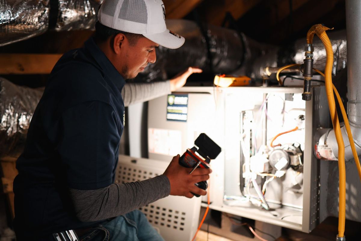 Rise technician testing a furnace in an attic